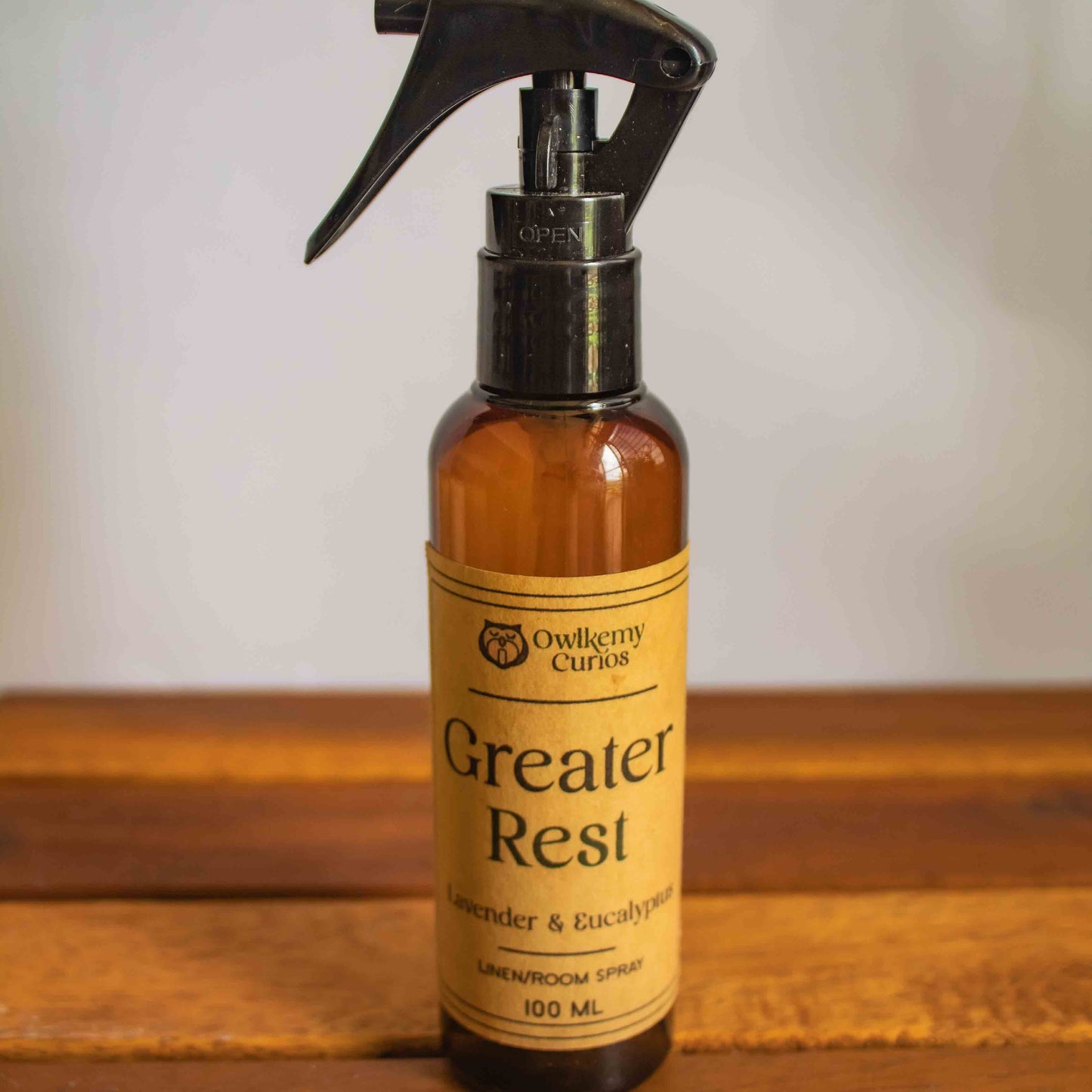 Amber spray bottle labeled 'Greater Rest' on a wooden surface with a white background