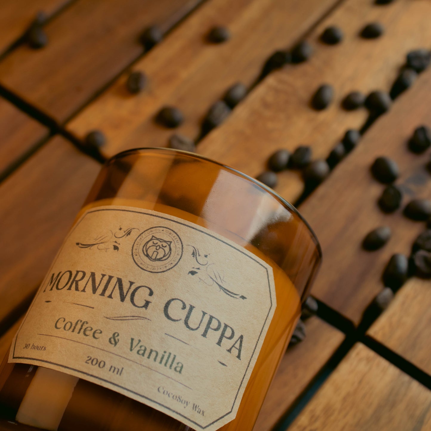 Bottle of 'Morning Cuppa Coffee & Vanilla' on a wooden surface with coffee beans.