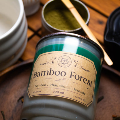 Bamboo Forest candle with a label on a wooden surface with other candles and containers.