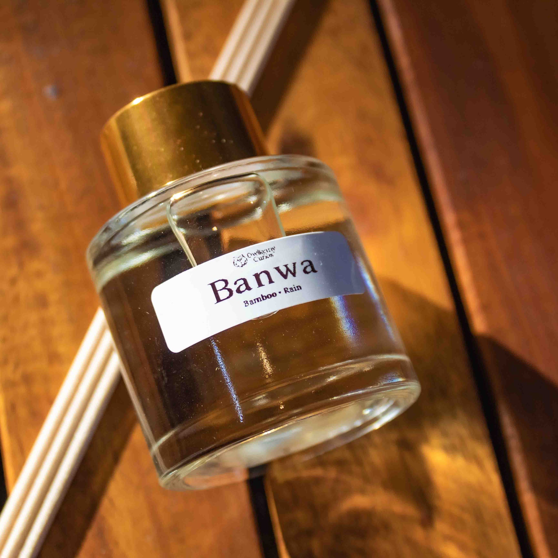 Small glass jar with gold cap and 'Banwa' label on a wooden surface