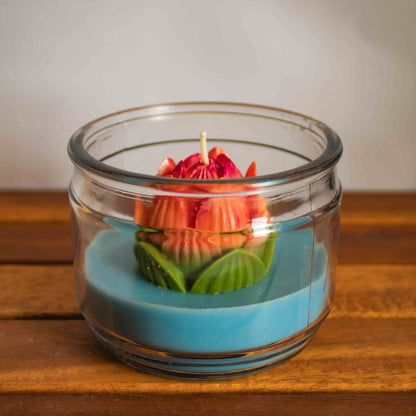 Candle in a glass jar with a floral design on a wooden surface