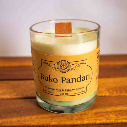 Candle with a label reading 'Buko Pandan' on a wooden surface.