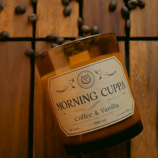 Jar of 'Morning Cuppa' coffee and vanilla on a wooden surface with scattered coffee beans.