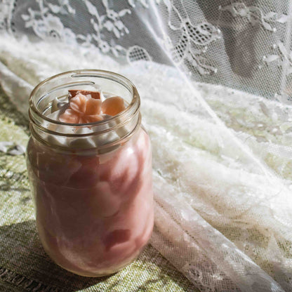 Glass jar with pink contents on a lace fabric background